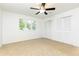 A bright bedroom features neutral carpet, a ceiling fan, and a window and closet for storage at 2730 Burtz Dr, Marietta, GA 30068