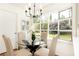 Cozy dining area featuring a glass table, modern chandelier, and views of the garden at 2730 Burtz Dr, Marietta, GA 30068