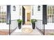 Charming front porch with black accents, a patterned rug, and stylish planters flanking the doorway at 2730 Burtz Dr, Marietta, GA 30068