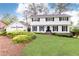 Charming white two-story home with a well-manicured lawn, mature landscaping, and an attached two-car garage at 2730 Burtz Dr, Marietta, GA 30068