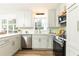 Well-lit kitchen with white cabinets, stainless steel appliances, and wood flooring at 2730 Burtz Dr, Marietta, GA 30068