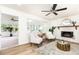 Bright living room with white brick fireplace, modern ceiling fan, and view to sunroom at 2730 Burtz Dr, Marietta, GA 30068