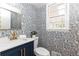 Stylish powder room with patterned wallpaper, modern fixtures, and gold accents at 2730 Burtz Dr, Marietta, GA 30068