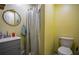Simple bathroom featuring a toilet, shower with a shower curtain, and a mirror above the sink at 8053 Duralee Ln, Douglasville, GA 30134
