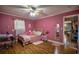 Pink themed bedroom featuring a bed, desk, and hardwood floors at 8053 Duralee Ln, Douglasville, GA 30134