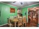 Charming dining area with green walls, a wooden table, and a view into the living room, creating a cozy and inviting space for meals at 8053 Duralee Ln, Douglasville, GA 30134