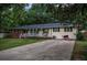 Inviting single-story home with a brick and siding exterior, a cozy front porch, and a spacious driveway, set in a tranquil setting at 8053 Duralee Ln, Douglasville, GA 30134