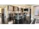 Finished basement wet bar with modern lighting, black herringbone wood floors, and seating at 1125 Lake Shore Overlook, Alpharetta, GA 30005