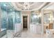 Modern bathroom features a large glass enclosed shower, marble countertop, and statement chandelier at 1125 Lake Shore Overlook, Alpharetta, GA 30005