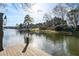 Scenic lake view showcasing the waterfront property with a private dock on a sunny day at 1125 Lake Shore Overlook, Alpharetta, GA 30005