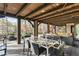 Large covered outdoor patio with a wood plank ceiling and an elegant dining table at 1125 Lake Shore Overlook, Alpharetta, GA 30005