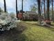 Traditional two-story home surrounded by lush greenery and mature trees at 1153 Staples Sw Dr, Lilburn, GA 30047