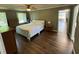 Bedroom features hardwood floors, ceiling fan, and natural light from the large windows at 1153 Staples Sw Dr, Lilburn, GA 30047