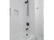 Modern bathroom features a soaking tub and shower with black fixtures and white tiling at 317 Community Sw Dr, Mableton, GA 30126
