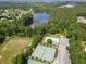 Scenic aerial shot of a community featuring a pond, swimming pool, tennis courts and surrounded by dense trees and landscaping at 330 Bay Grove Rd, Loganville, GA 30052