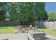 Backyard featuring a stone firepit with seating and mature trees at 330 Bay Grove Rd, Loganville, GA 30052