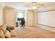 A versatile bonus room features a projector screen, plush carpet and natural light from a window and a ceiling fan with lights at 330 Bay Grove Rd, Loganville, GA 30052