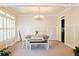 Bright dining room featuring wainscoting, a chandelier, and a dining table with white chairs and a bench at 330 Bay Grove Rd, Loganville, GA 30052