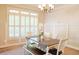 Dining room with a large window, paneled wall, chandelier, and a wooden dining table with chairs and a bench at 330 Bay Grove Rd, Loganville, GA 30052
