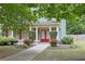 Home featuring a charming front porch with red doors and manicured bushes at 330 Bay Grove Rd, Loganville, GA 30052