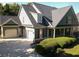 Charming home featuring a three car garage, front porch, mature trees, and landscaping at 330 Bay Grove Rd, Loganville, GA 30052