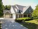 Charming home featuring a three car garage, front porch, mature trees, and landscaping at 330 Bay Grove Rd, Loganville, GA 30052
