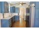 Kitchen featuring blue cabinets, granite countertops, stainless steel appliances, and hardwood floors at 330 Bay Grove Rd, Loganville, GA 30052