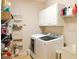 This laundry room has a front load washer and dryer, overhead cabinets and an organization rack at 330 Bay Grove Rd, Loganville, GA 30052