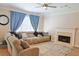 Living room featuring sectional couch, fire place, ceiling fan, and large window at 330 Bay Grove Rd, Loganville, GA 30052