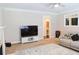 Living room featuring sectional couch, tv, and access to powder room at 330 Bay Grove Rd, Loganville, GA 30052