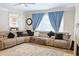 Living room featuring sectional couch, ceiling fan, and large window at 330 Bay Grove Rd, Loganville, GA 30052