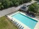 Overhead shot of community pool, featuring lounge chairs, tables, and a nearby building surrounded by landscaping and a parking lot at 330 Bay Grove Rd, Loganville, GA 30052