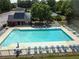 Aerial view of a large community pool with lounge chairs and tables surrounded by a black metal fence and mature trees at 330 Bay Grove Rd, Loganville, GA 30052