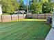 Large backyard featuring healthy green grass, a wooden fence, and an AC unit at 4811 Lake Park Ter, Acworth, GA 30101