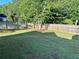 Spacious fenced-in backyard featuring lush green grass and mature trees at 4811 Lake Park Ter, Acworth, GA 30101