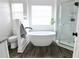 Modern bathroom with a soaking tub, glass enclosed shower, and dark wood-look flooring at 4811 Lake Park Ter, Acworth, GA 30101