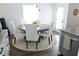 Well lit dining room shows a round wood table with six white chairs on top of a jute rug at 4811 Lake Park Ter, Acworth, GA 30101