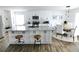Modern kitchen with white cabinetry, granite counters, stainless appliances, island with bar stools, and dining area at 4811 Lake Park Ter, Acworth, GA 30101