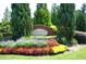 Landscaped community entrance sign with seasonal flowers and manicured shrubs at 634 Friars Head Dr, Suwanee, GA 30024