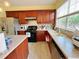 Bright kitchen with wooden cabinets, stainless appliances and a window over the sink at 634 Friars Head Dr, Suwanee, GA 30024