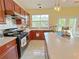 Well-lit kitchen features wooden cabinetry, stainless steel appliances, and a bright window over the sink at 634 Friars Head Dr, Suwanee, GA 30024