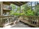Enjoy the wooded view from this cozy covered back porch with neutral colored railing at 906 Country Park Se Dr, Smyrna, GA 30080