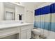 Simple bathroom featuring single sink vanity, toilet, and shower with blue striped curtain at 906 Country Park Se Dr, Smyrna, GA 30080