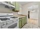 Traditional-style kitchen with gas range, light green cabinets, and view to dining room at 906 Country Park Se Dr, Smyrna, GA 30080