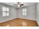 Relaxing bedroom featuring two bright windows, a ceiling fan, and gleaming hardwood flooring at 243 Woodview Ln, Smyrna, GA 30082