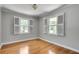 Bedroom with neutral paint and wood floors, featuring bright shuttered windows at 243 Woodview Ln, Smyrna, GA 30082