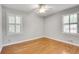 Bright bedroom with hardwood floors, neutral walls, two windows with white shutters, and ceiling fan at 243 Woodview Ln, Smyrna, GA 30082