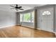Cozy living room featuring hardwood floors, fresh paint, a ceiling fan, and a large bright window at 243 Woodview Ln, Smyrna, GA 30082