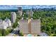 Stunning aerial view showcasing a luxury high-rise condo building amidst lush greenery and a vibrant cityscape at 2479 Peachtree Ne Rd # 1801, Atlanta, GA 30305