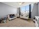 bedroom with floor-to-ceiling windows, offering city views, a crib, and a small sofa at 2479 Peachtree Ne Rd # 1801, Atlanta, GA 30305